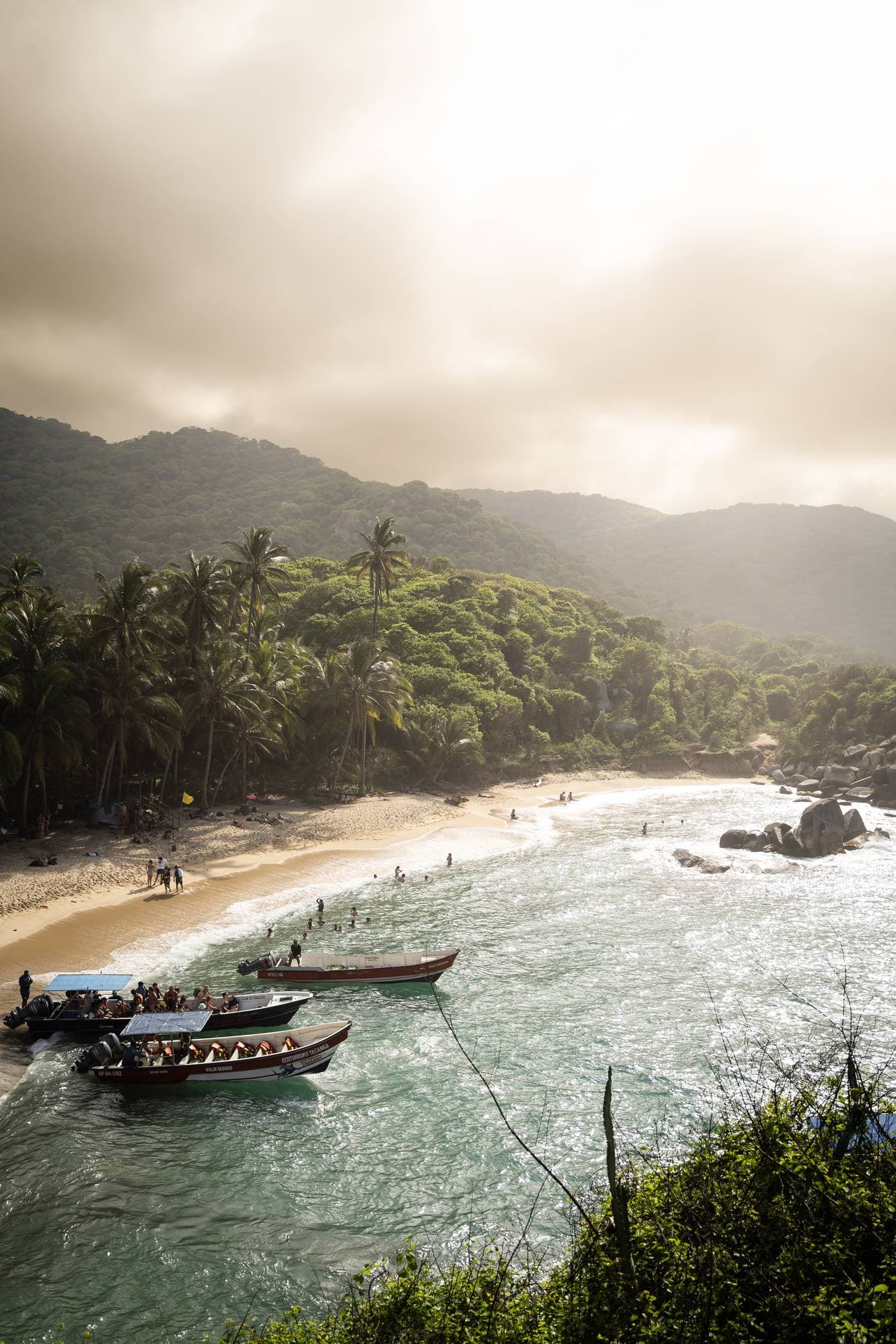 Boats on a palm-fringed Caribbean beach in Colombia